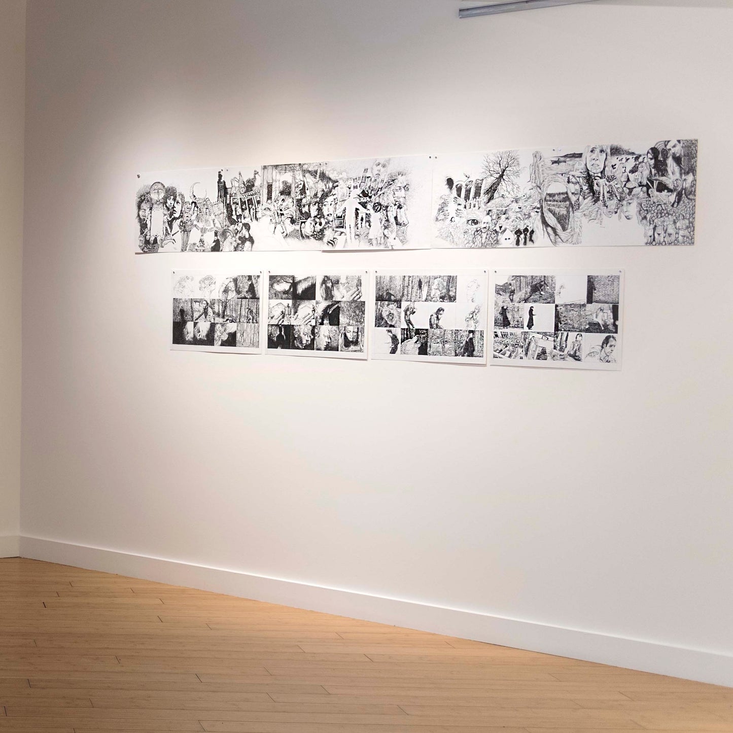 Exhibition display of graphic novel panels, featuring ink drawings, disoriented people, woods, leaves and movement.